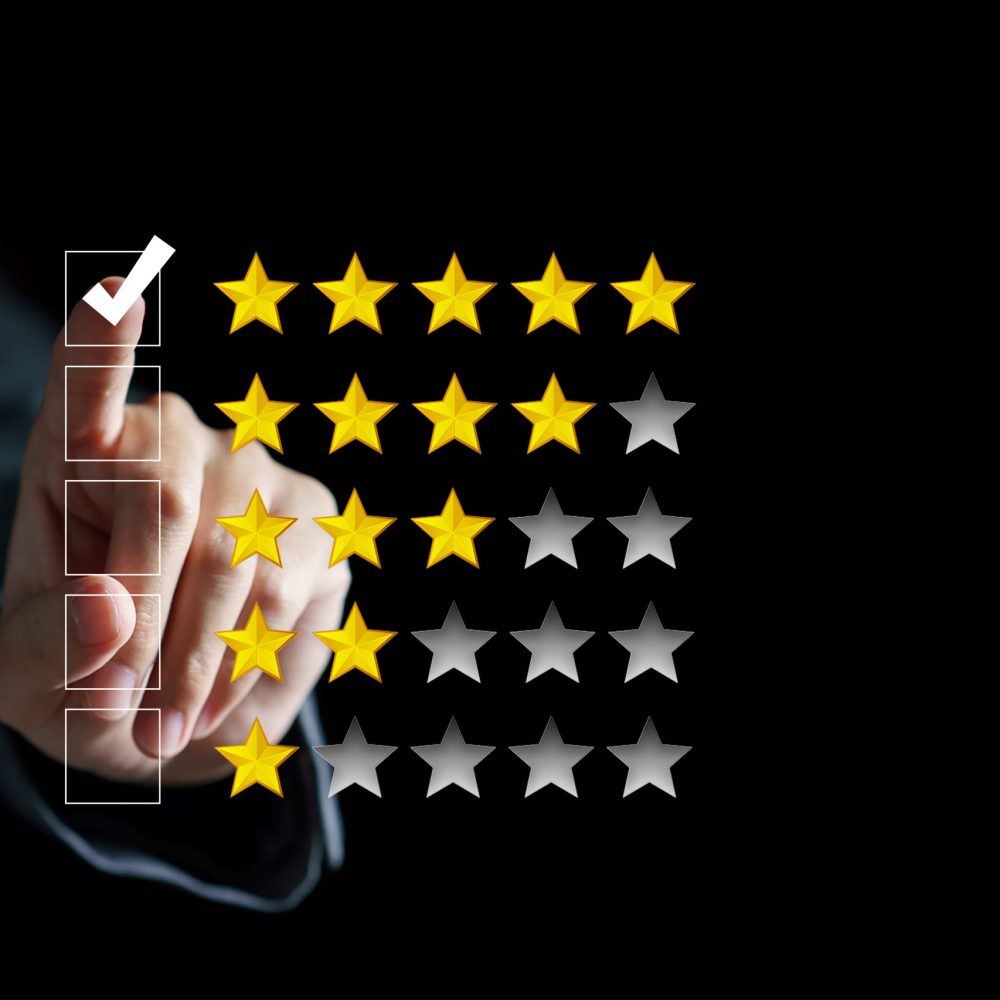 Hand touching and doing mark to five yellow stars on black background, the best customer satisfaction and evaluation for good quality product and service.